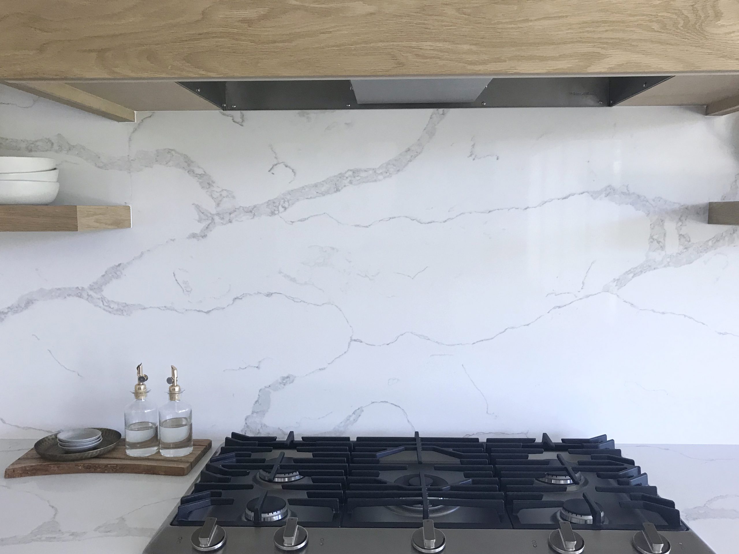 kitchen range below a full height natural stone back splash